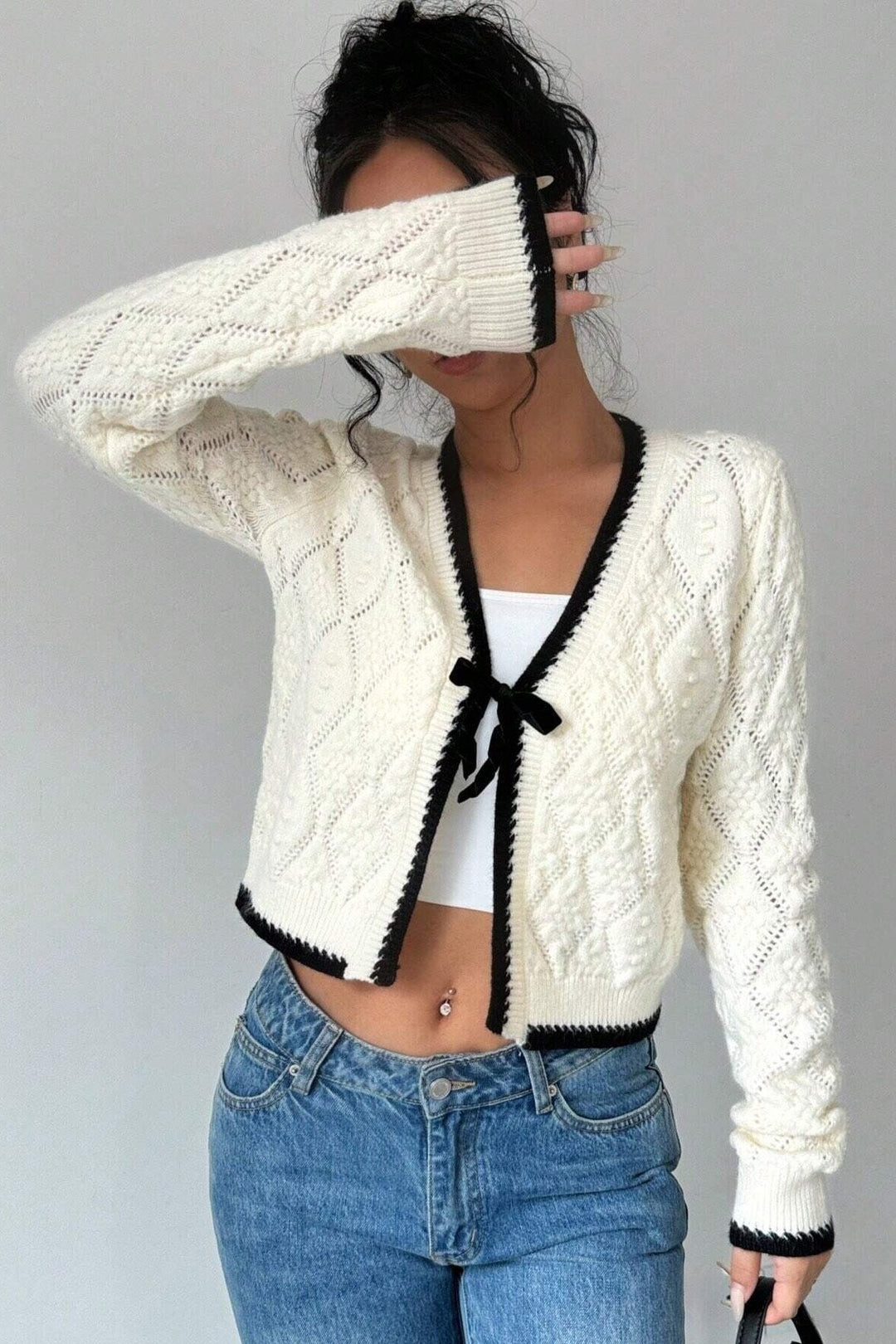 Kurze Strickjacke mit Lochmuster, Schleife und kontrastfarbenen Bordüren – Mila